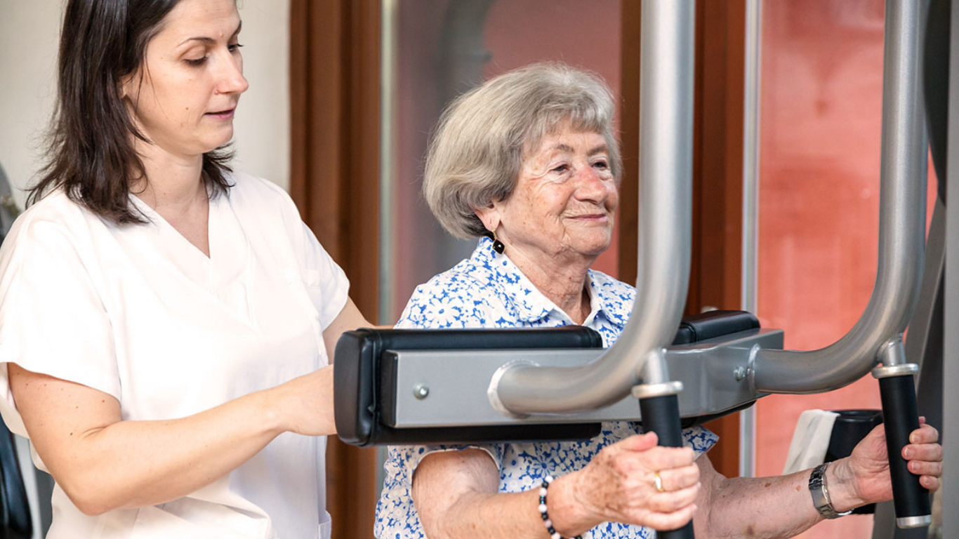 Therapeutin mit Patient am Gerät