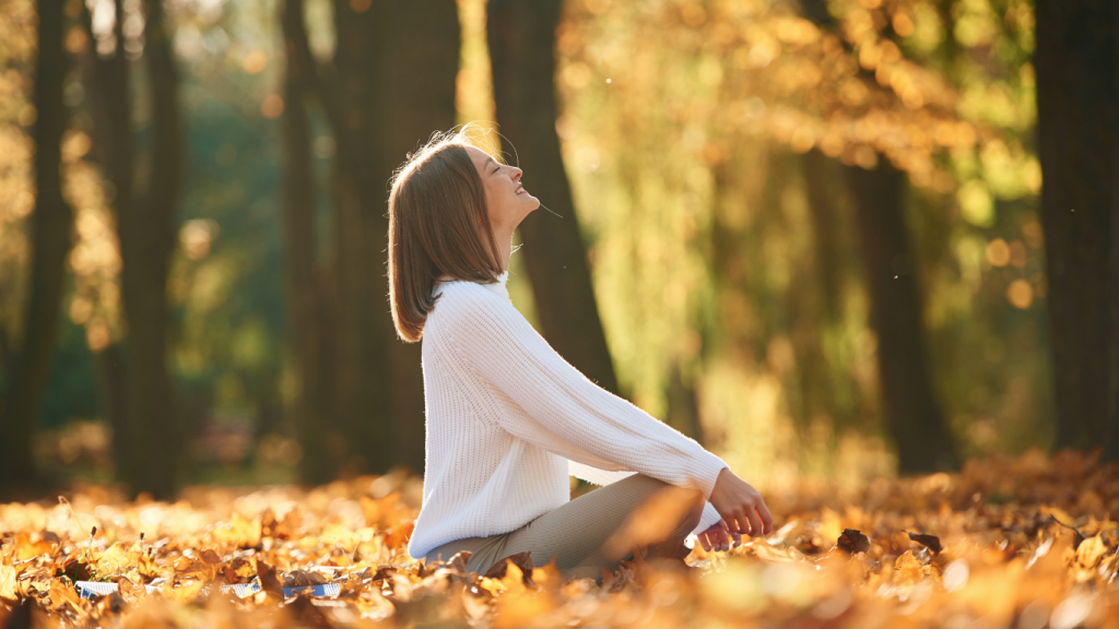 Herbst, Regen, Kälte: Warum tun Gelenke bei manchen Menschen jetzt mehr weh? Frau, die mitten im Laub drausen sitzt